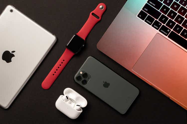 Different Apple products flat on gray background.