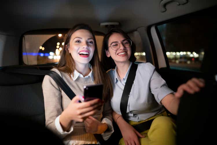 Young women having fun while driving in the taxi