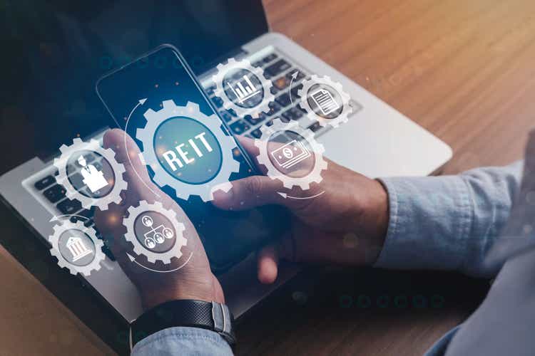 Businessmen holding a smartphone with icons of Real Estate Investment Trust REIT banner web icon for Mutual Fund and investment, Real estate, property, manager, broker, investor and return.
