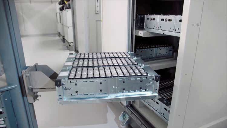 close-up of an electric car battery on top of a forklift truck going into a cabinet where there are more batteries. In an electric car battery factory.
