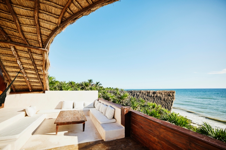 Wide shot of sitting area on deck of luxury suite at tropical resort