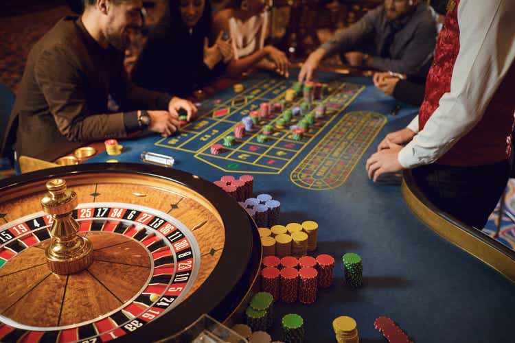 Hand of a croupier on a roulette whell in a casino.