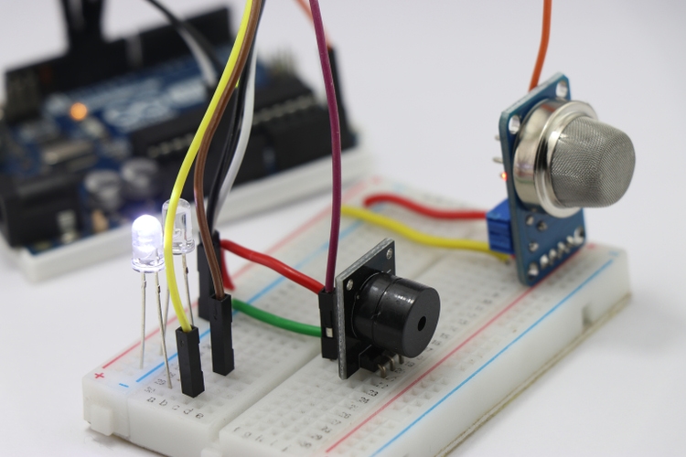 Side view of Different electronic components on a breadboard circuit with microcontroller on the background showing the concept of prototyping