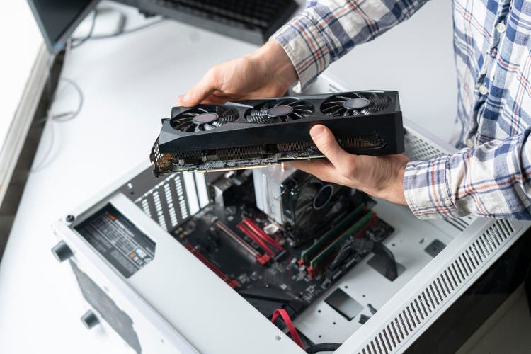 new modern powerful computer video or graphics card installed in computer by serviceman