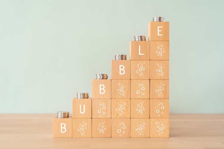 Wooden blocks with "BUBBLE" text of concept and coins.