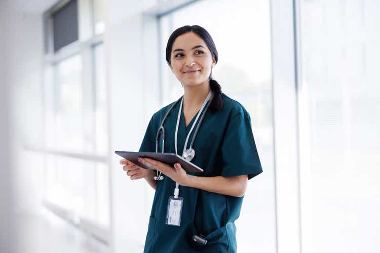 Female doctor in hospital looking at digital tablet