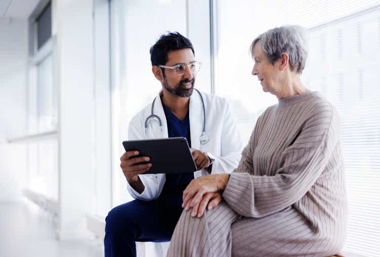 Doctor and patient in conversation, looking at digital tablet