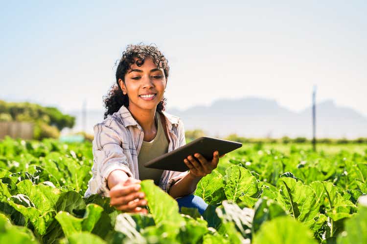 Shot of a young woman using a digital tablet while inspecting crops on a farm