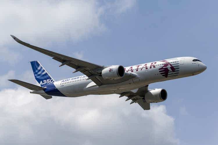 Airbus A350 aircraft with a hybrid Airbus/Qatar Airways livery departing Farnborough Airport.