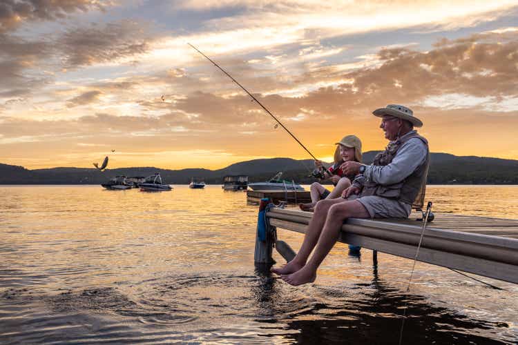 Grandfather and Grandson Fishing At Sunset in Summer, Quebec, Canada