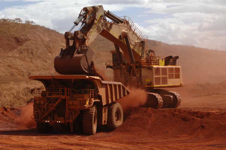 Excavator loading ore into a haul truck.