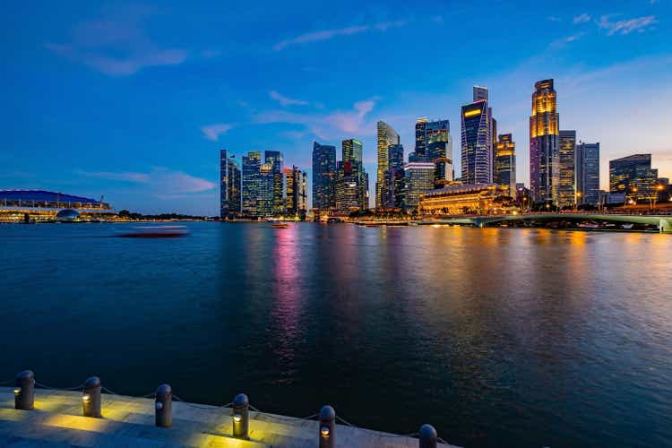 Cityscape of Symbolic and Iconic Buildings in Singapore with Light Trail from Boat with Long Exposure around Marina Bay at Night time with Reflection Trail Lights