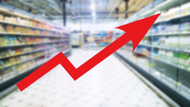Red growing up large arrow on abstract blur image of supermarket background. Bar charts and graphs. Price grocery rises. Inflation concept. Retail industry. Finance and Economy. Stock Market. Store.