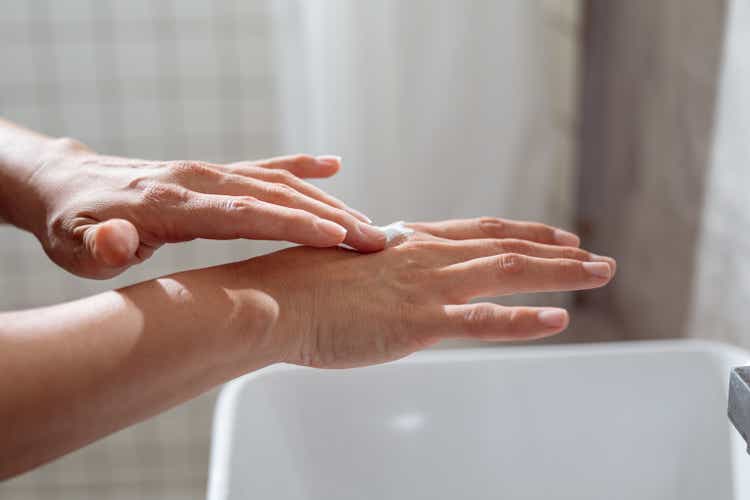 Anonymous Young Caucasian Woman Applying a Hand Cream in the Bathroom