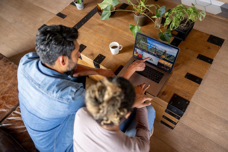 Happy couple at home booking a trip online