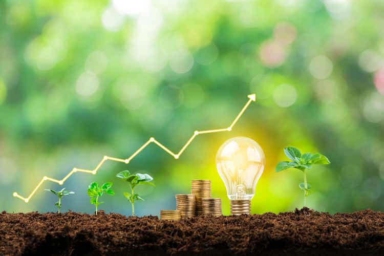 Financial growth graph, coins, plants and light bulb