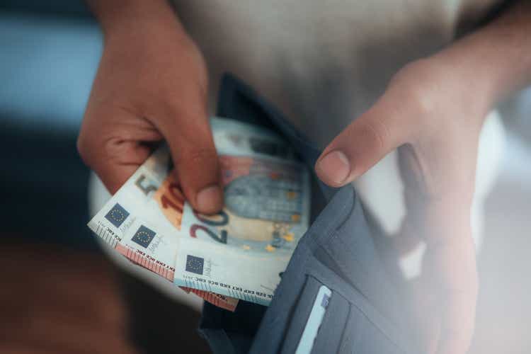 Young man holding in hands wallet with euro money