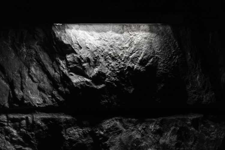 Black rough rock blocks with spotlight, cave wall texture