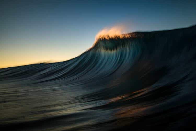 Dark majestic wave cresting in golden morning light