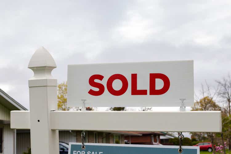 White sold sign in front of a house. Real estate concept