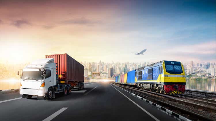 Global business logistics import export of Container Truck on highway and Freight Train with Cargo Plane at city background, Sunset time, Transportation industry concept, Depth blur effect