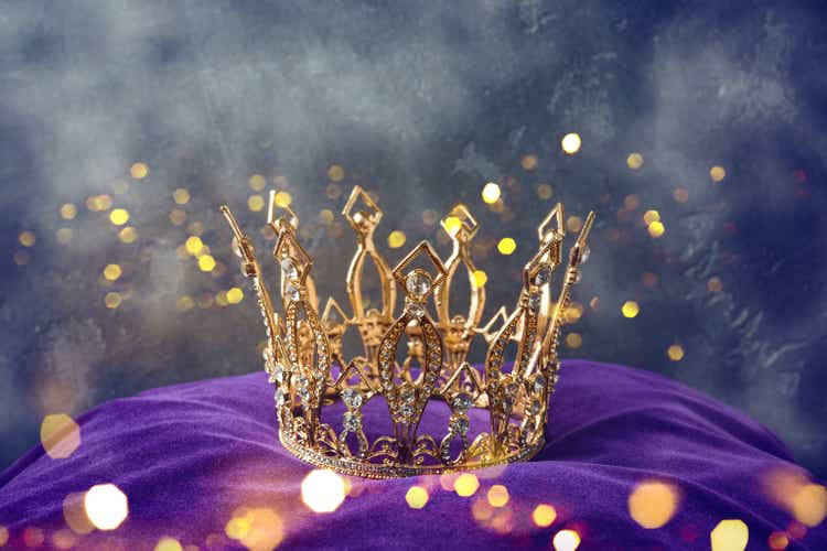 Golden queen crown over mysterious dark background. Mythical or fantasy world concept