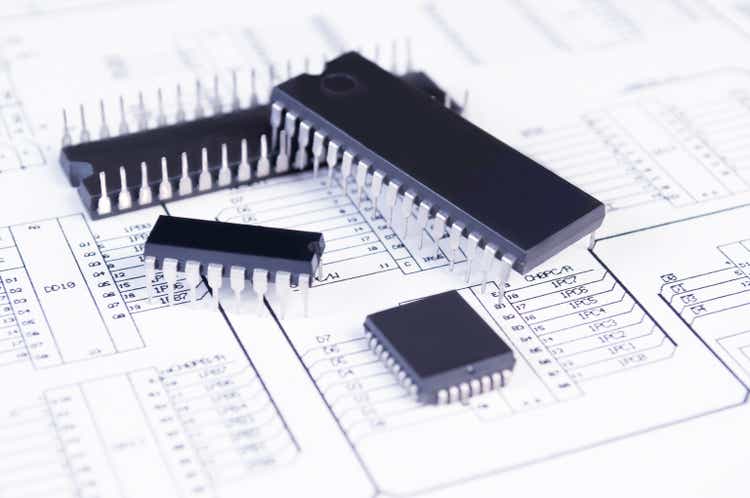 Electronics components on background of schematic circuit diagram. Concept for development and design of electronic devices.