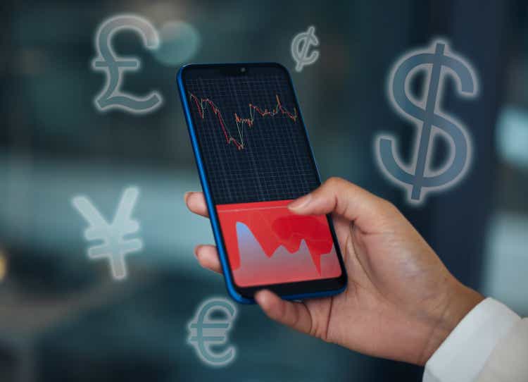 Cropped shot of an unrecognisable businesswoman using her cellphone to check the stock market in her office at night