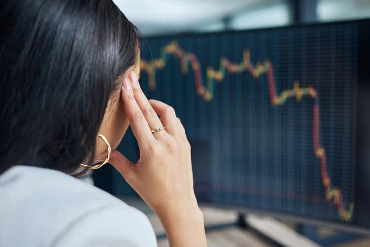 Shot of an unrecognisable businesswoman sitting in her office at night and feeling stressed while using her computer