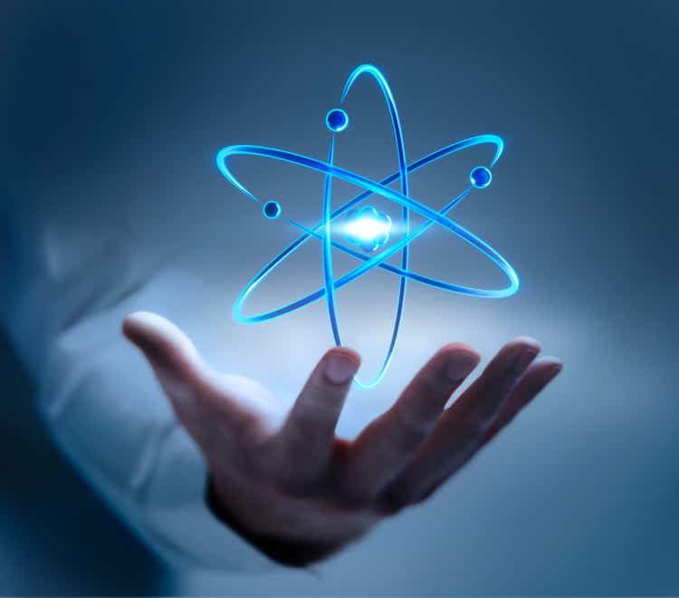 Hand with atom nucleus and electrons symbol