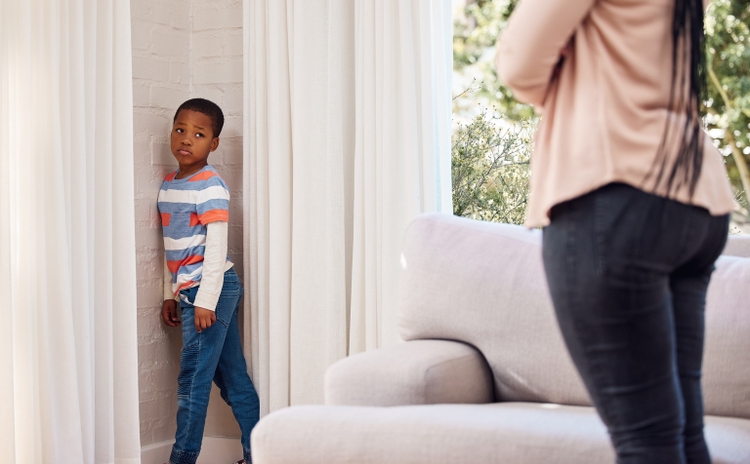 Shot of a little boy standing in the corner as a punishment at home