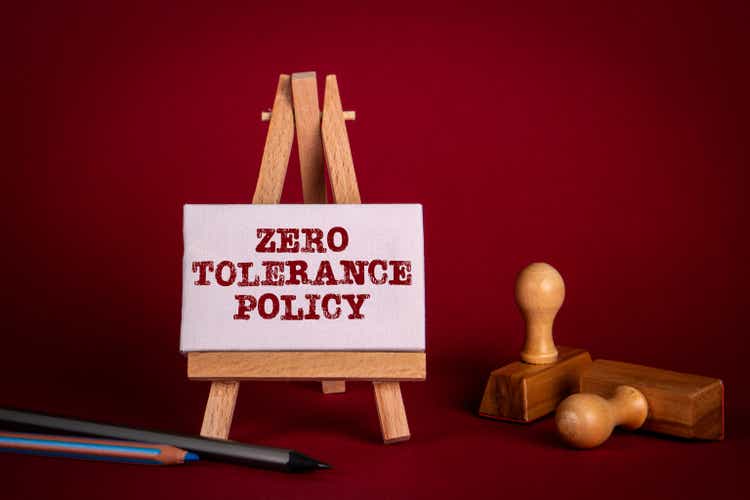Zero Tolerance Policy. Miniature easel and wooden stamps on a bright red background