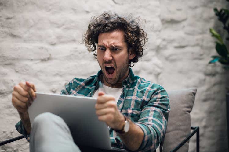 Shocked. Shot of an attractive young businessman sitting alone in his office and feeling stressed