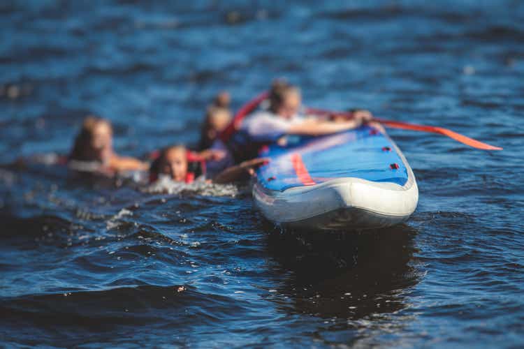 Group of young sup surfers fall from SUP stand up paddle board, women drowning, concept of fail solving problems, team work and survival, boat accident during stand up paddling, standup paddleboarding