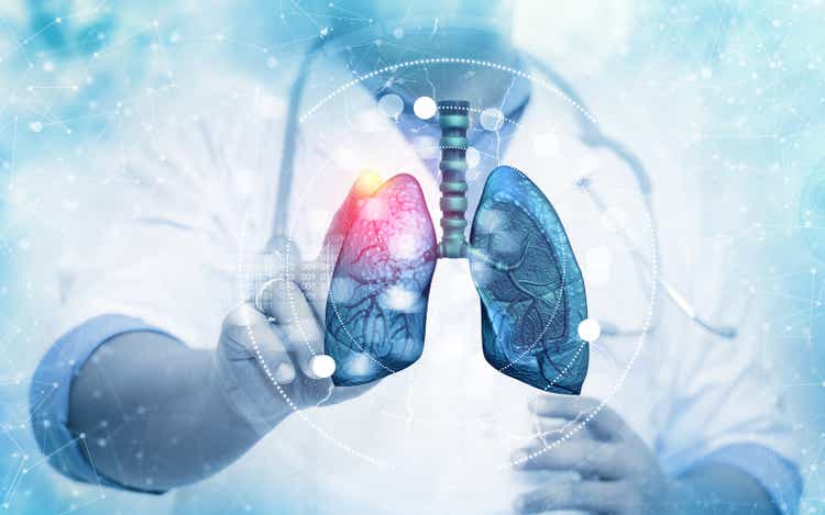 The doctor touching the human lung system on blurred background