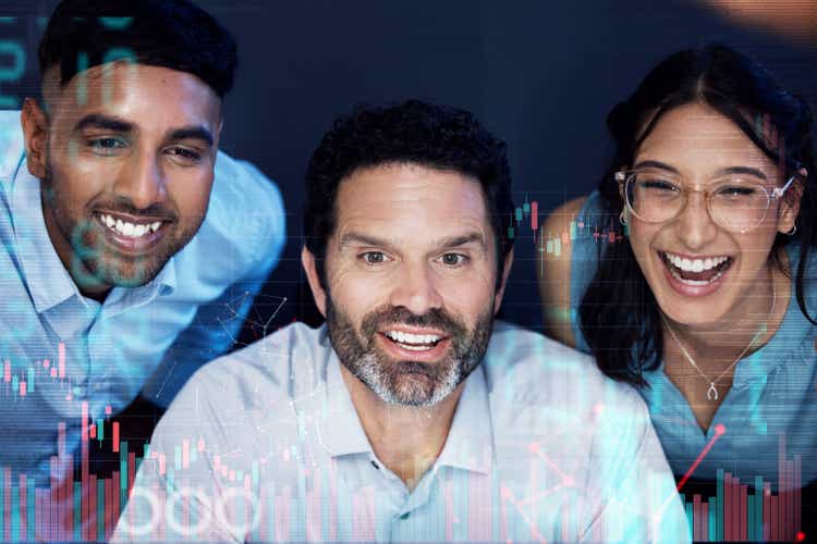 Shot of a group of businesspeople connecting to a user interface in an office at night