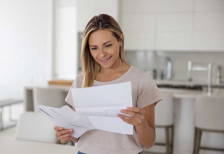 Woman at home reading a letter in her mail