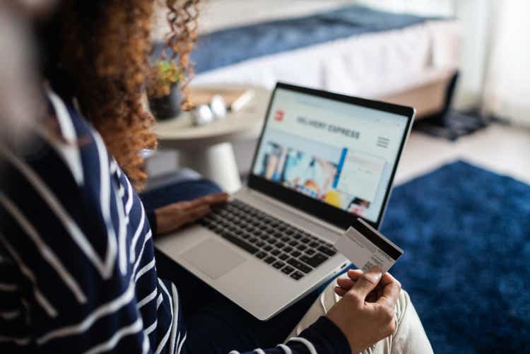 young woman shopping online using laptop at home