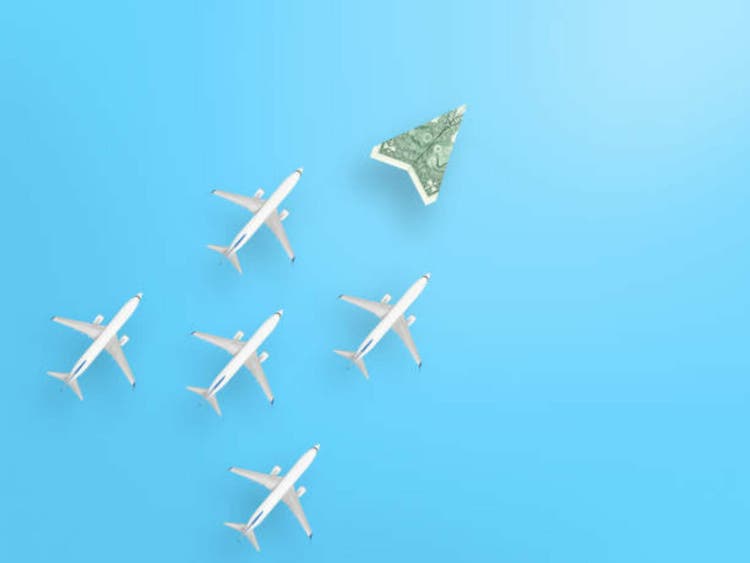 Dollar bill plane and group of airplanes on blue background