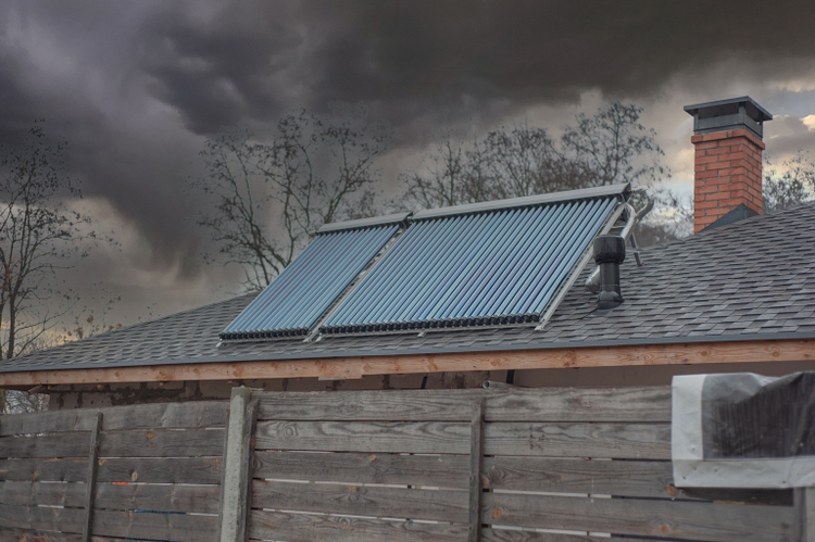 Energy generation sunpower collecting solar panels on a roof of farmhouse roof with opened window.