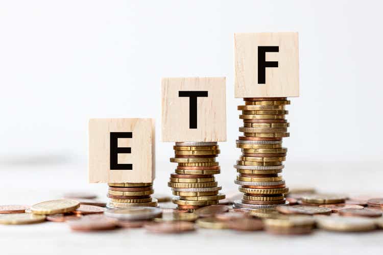 Concept - ETF Exchange Traded Fund wording on wooden cubes with coins