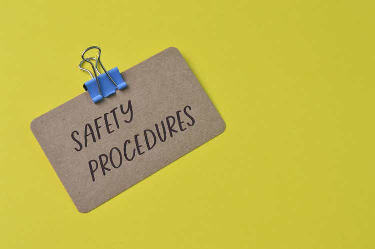 Brown card with text SAFETY PROCEDURES isolated on a yellow background