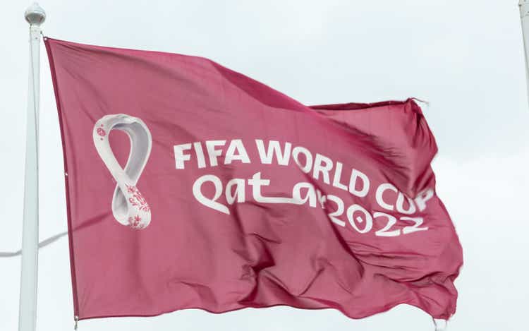 Maroon Fifa World Cup Qatar 2022 flag flying in the sky above Doha