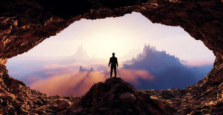 Dramatic View of Adventurous Man standing inrocky cave. Mountain Landscape