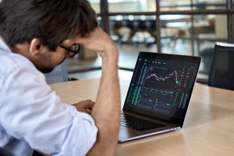 Stressed business man analyzing trading stock market trading fall down.