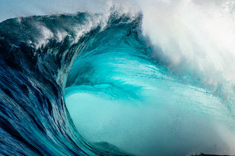 Detalhe de close-up de uma poderosa onda azul-esverdeada quebrando violentamente no recife