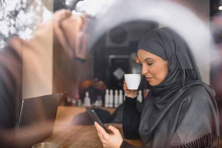 Beautiful Female With Hijab Exploring Social Media While Drinking Good Coffee