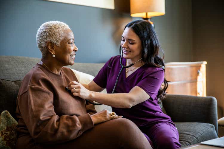 Nurse checking senior woman"s vital signs in her home