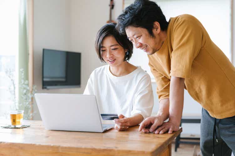 Couple enjoy online shopping at home