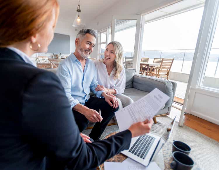 Happy mature couple meeting investments and financial advisor at home